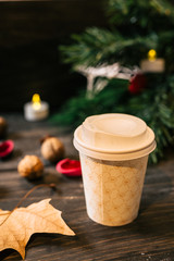 cup of coffee in paper cup on christmas decorated table