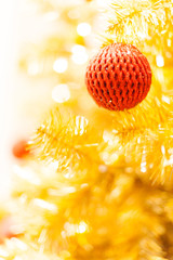 Glittering Bauble with Glowing Sparkling Gold defocused Light (bokeh) Illumination background with decorated Christmas Tree. Special Holidays, Festival design decoration, New Year Celebration, Party.