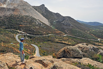 Kid looking at mountain road standing at the top