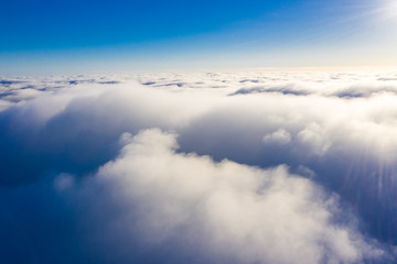 Naklejka premium Above white clouds aerial. Flying over the ground
