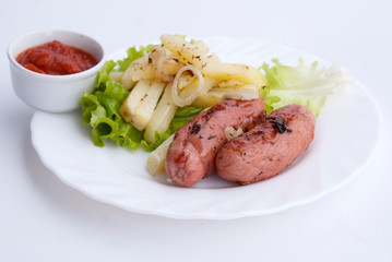 Baked sausages with french fries and vegetables, German cuisine, top view
