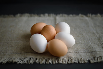 six eggs at a canvas on a dark background.