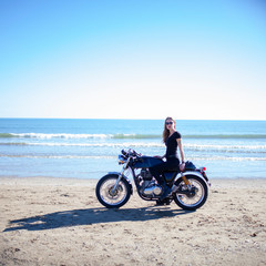 Fototapeta premium Kobieta z motocyklem obok plaży