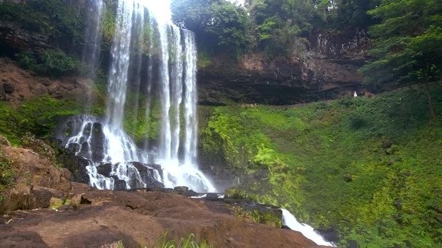 foamy waterfall streams fall from high level in park