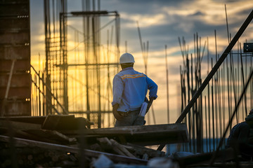 The foreman checking of construction worker on building site.