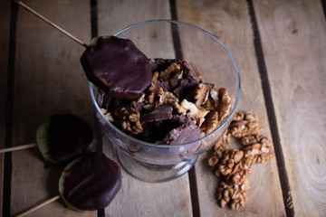Fresh homemade chocolate ice cream with pieces of walnuts.Fresh kiwi fruit sliced in circles dipped in dark chocolate. Homemade ice cream. Peeled walnuts.