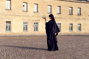 Young girl in a long black coat