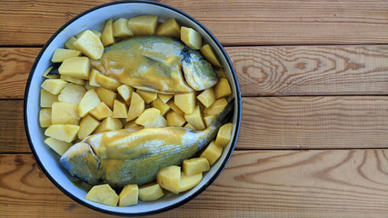 Preparation of gilt-head bream fish to be baked in oven with potatoes and mustard-honey sauce