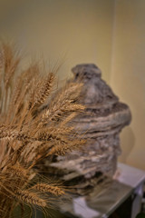 Wheat stalks with ancient Asian stone carving in the background