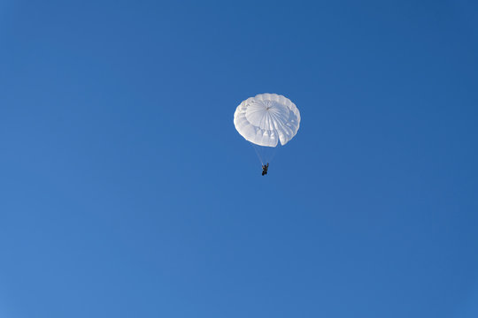 A military paratrooper is landing.