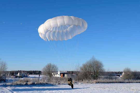 A military paratrooper is landing.