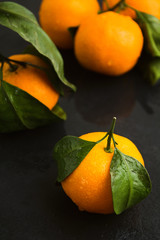 Closeup view of fresh healthy wet mandarin on black background