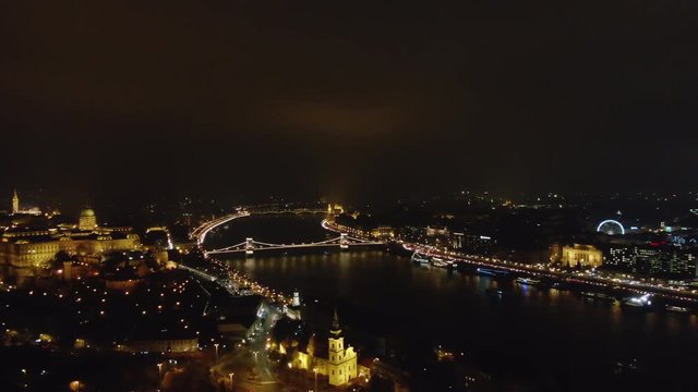 Picturesque drone view of glowing Budapest city with lights reflecting in channel in night time, Hungary