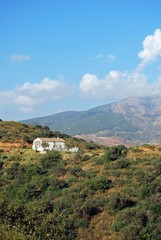 Fototapeta na wymiar View across countryside towards the Sierra de Mijas mountains with a traditional Spanish finca in the foreground near Fuengirola, Spain.