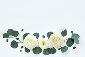 Flower spring frame with fresh branches of ranunculus and pion roses and eucalyptus leaves isolated on white background, flat lay and top view