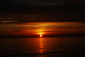 the sun sets over the sea