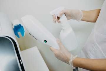 cropped shot of cosmetologist with laser hair removal apparatus in salon