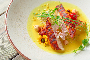 Marinated grilled healthy chicken breasts cooked on a summer BBQ and served with fresh herbs