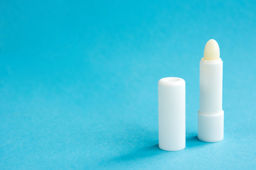 Hygiene lipstick on blue background.
