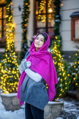 Young woman traveling for Christmas. Pink scarf. Concept Lifestyle, Urban, Winter, Vacation, Happy Christmas, New Year