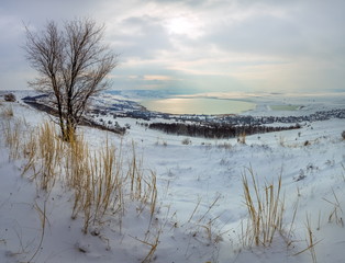 Winter lake in the snow. Lake snowy winter with clouds. Top view of the lake.