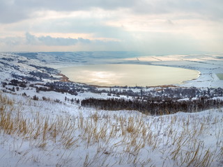 Winter lake in the snow. Lake snowy winter with clouds. Top view of the lake.