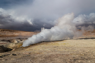 Fototapeta na wymiar Steam rising from a geyser in Altiplano, Bolivia