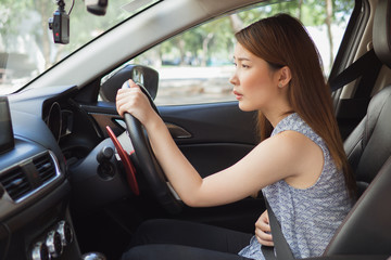 Naklejka premium Asian woman having painful stomachache in car while drive ,Female suffering from abdominal pain,Period cramps