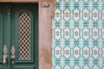 Close-up of a typical entrance door surrounded by patterned tiles (azulejos) inside the old town of Tavira, Algarve, Portugal