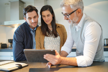  Kitchen salesman going through ideas with potential buyer couple