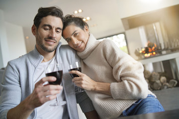  Couple relaxing by the fire enjoying glass of red wine