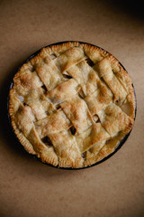 Apple pie with lattice decoration on beige background with a textile napkin