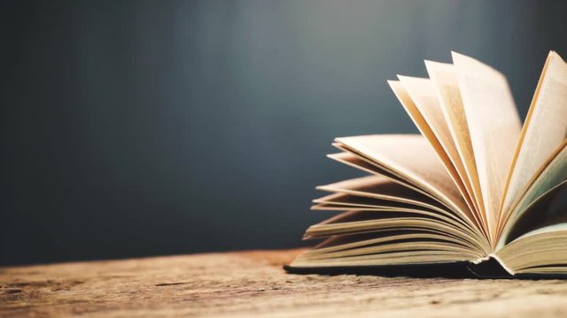 Books on a old wooden table. Beautiful dark background.