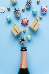 Champagne bottle with different christmas decoration on blue background. New year concept.