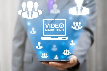 Video marketing concept. Man holds a smartphone and represents video marketing concept on a virtual screen.
