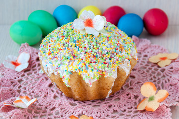 Easter cake on a table on a pink napkin and colorful eggs