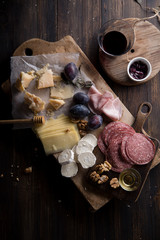 Cheese and meat board, snacks for wine with walnuts and honey