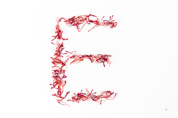 Alphabet made with saffron red gold of sardinia isolated on white clean background