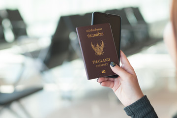 Travel concept. Closeup of woman hand holding Thai passport ready to boarding..