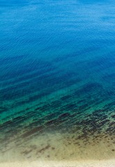 Fototapeta na wymiar clean blue sea, with a pebbly-rocky beach