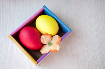 Red and yellow easter egg in a box on a table
