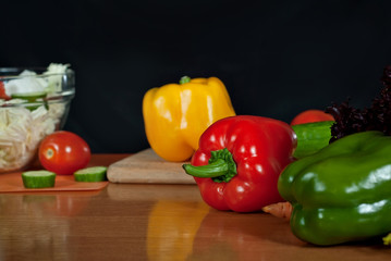 Vegetables on a wooden table on a black background. Clean colored vegetables on the kitchen table.