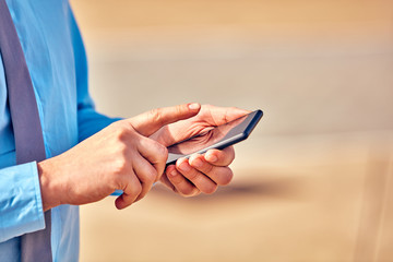 Businessman using his smartphone on the street.