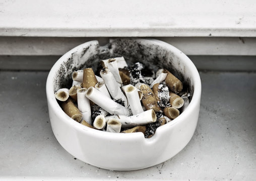 Heap of cigarette butts in a ashtray.