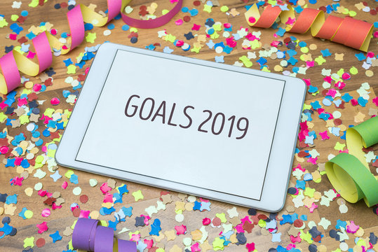 Goals 2019 written on tablet with confetti and streamer in background