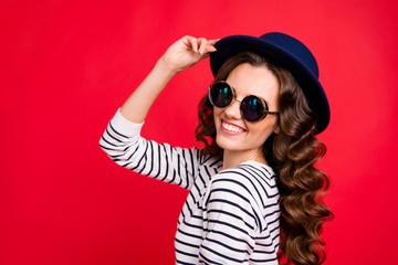 Close-up portrait of nice cute lovely sweet attractive gorgeous cheerful wavy-haired lady wearing striped pullover sunhat enjoying life isolated over bright vivid shine red background