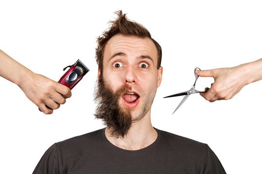 hand with clipper and hand with scissors cut overgrown unshaven guy with a beard on a white isolated background