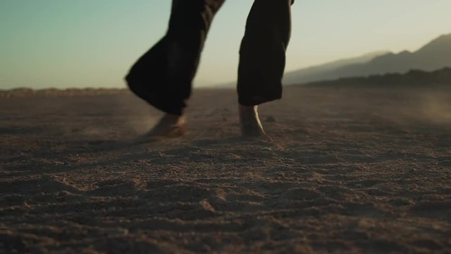 Close up of female legs barefoot dancing on the sand slow motion shaky footage