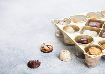 Luxury belgian chocolate and biscuit cookies selection in original golden tray and white kitchen table background.