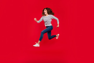 Full length size body photo of fly high charming she her girl quickly running to store shopping mall selling wearing white casual striped sweater denim jeans on red vivid bright background